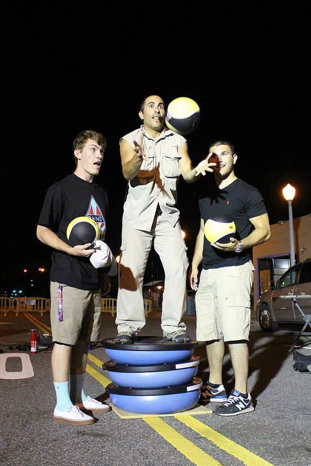 Three men are playing a game with frisbees.