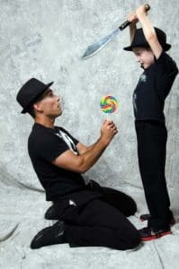 A man and boy in black shirts and hats.