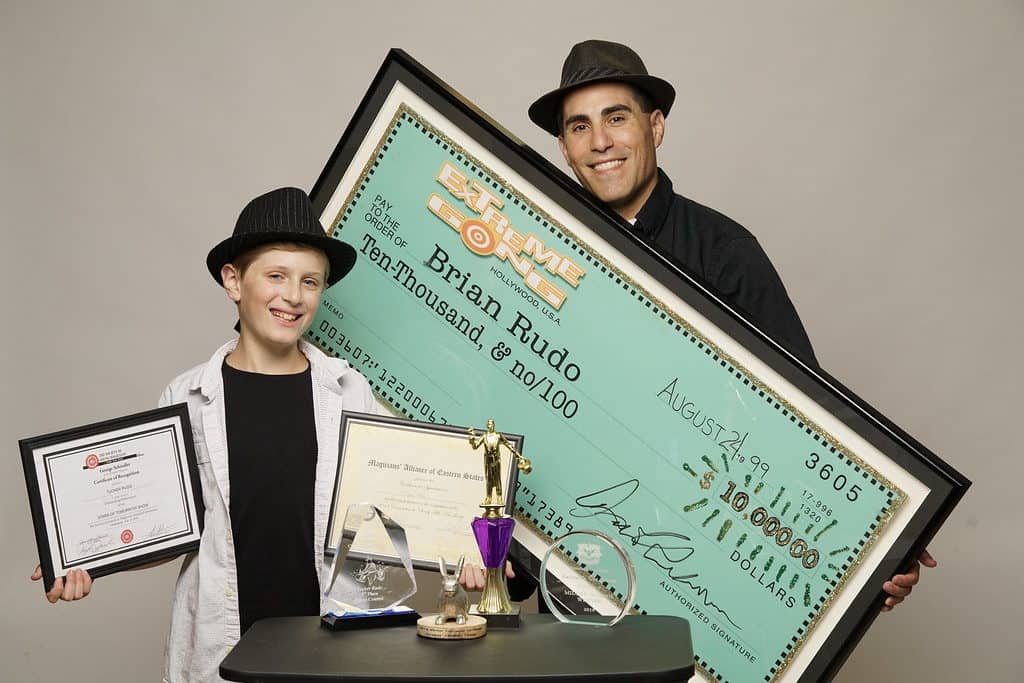 Two people holding a large cheque and a table